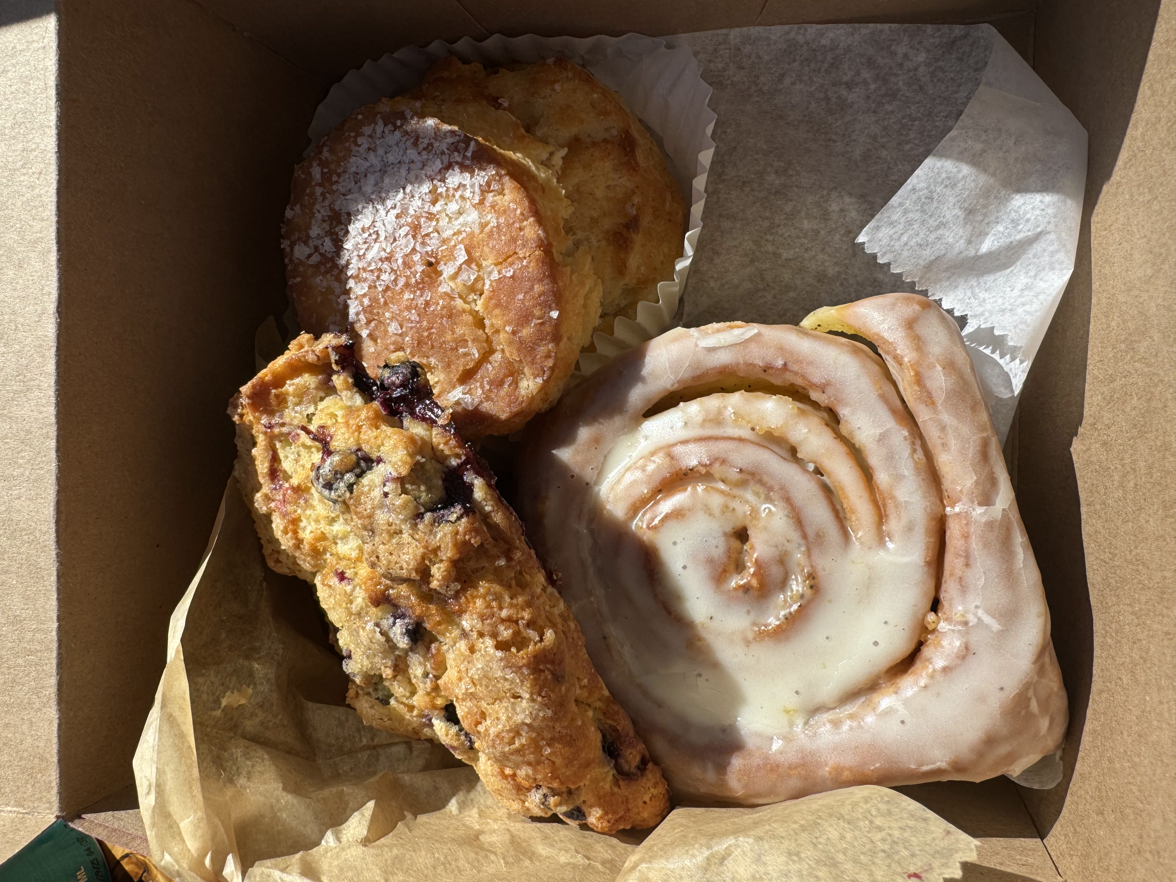 A box of Maine bakery treats — blueberry scone, sea salt biscuit, and cinnamon roll
